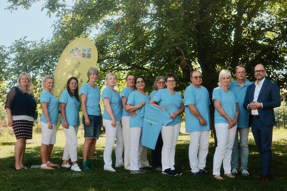 Im Bild außer den genannten noch 10 Mitarbeitende der Diakoniestation mit gespendeten T-Shirts